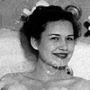 Smiling, dark-haired woman in a bathtub